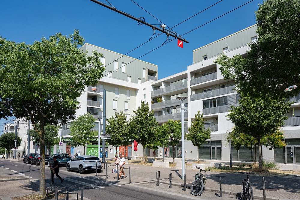 Place avec des commerces et des piétons traversant la route